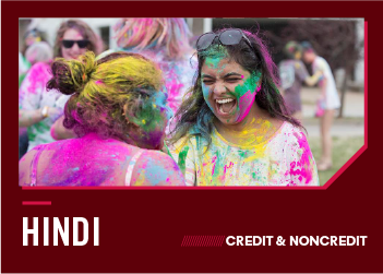 Women covered in bright festival powders laugh together during a Holi celebration.