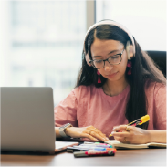 Student studying with a laptop and notes.